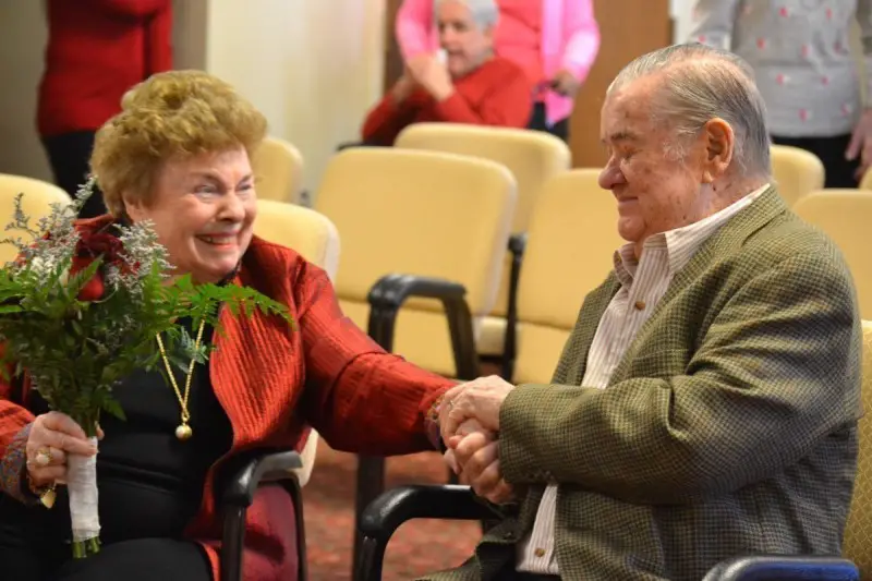 an image of an elderly couple exchanging loving glasses as they celebrate the wedding vows renewal ceremony