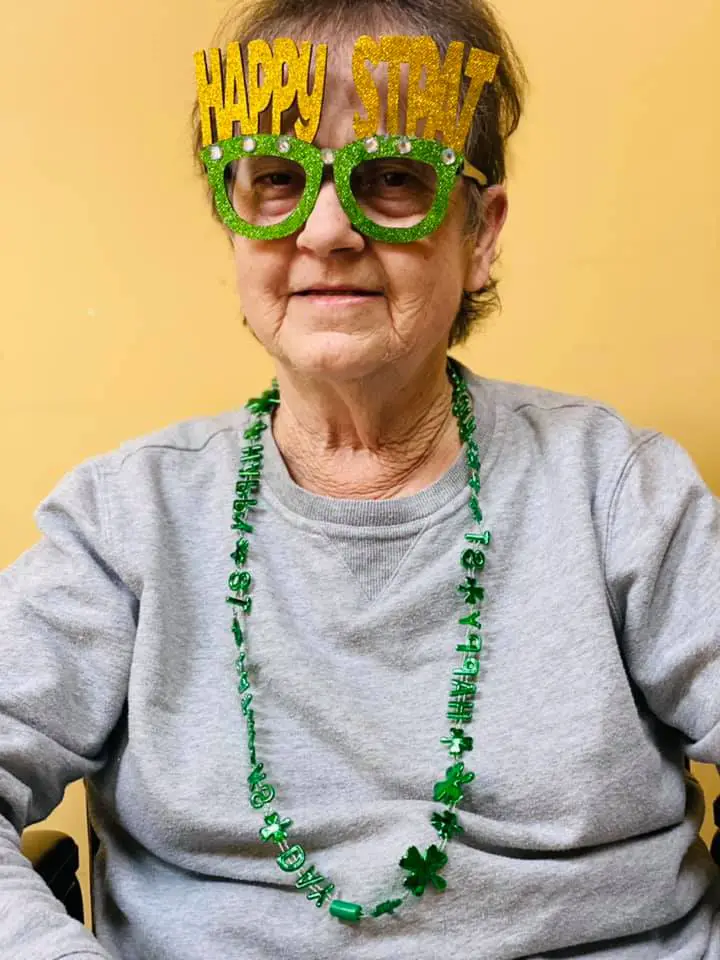 Elderly woman wearing a clover themed lei