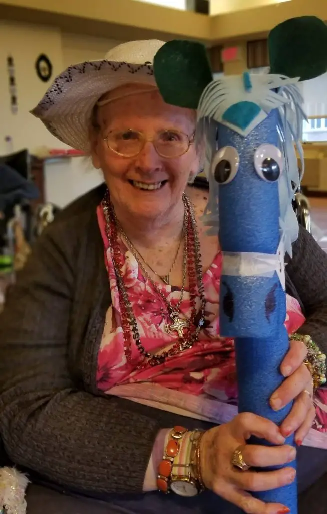 Old woman holding a crafted horse