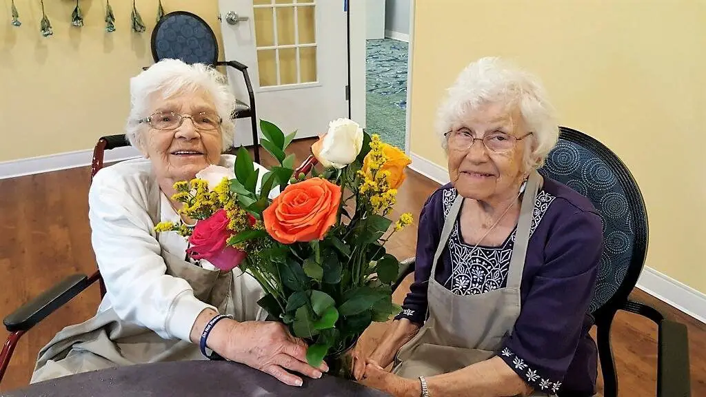 elderly women holding DIY decorative flowers for the wedding vows renewal event