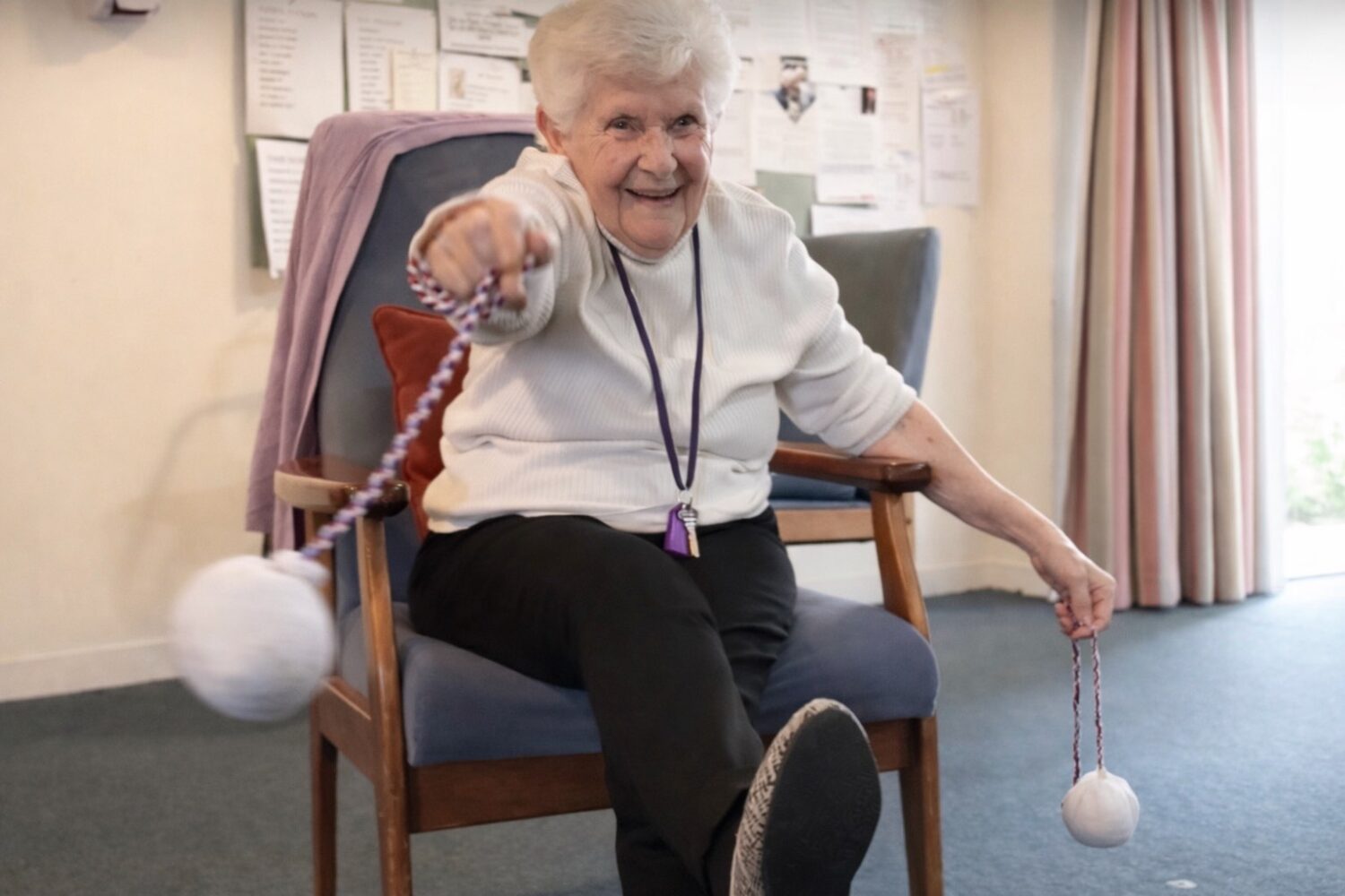 photo of a senior seated and swinging a corded sock poi