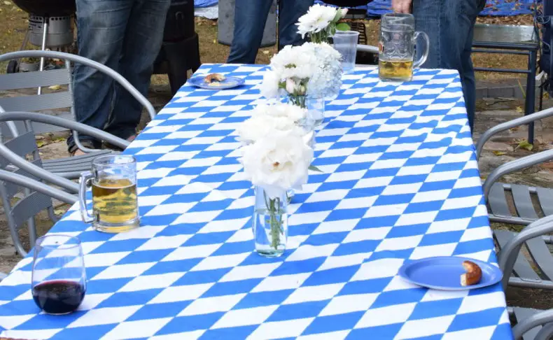 blue and white checkered table cloth and other table decorations for the oktoberfest theme day