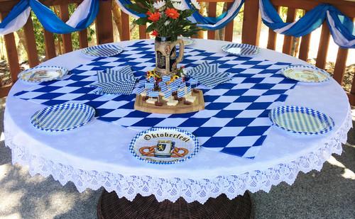 blue and white checkered table cloth and other table decorations for the oktoberfest theme day