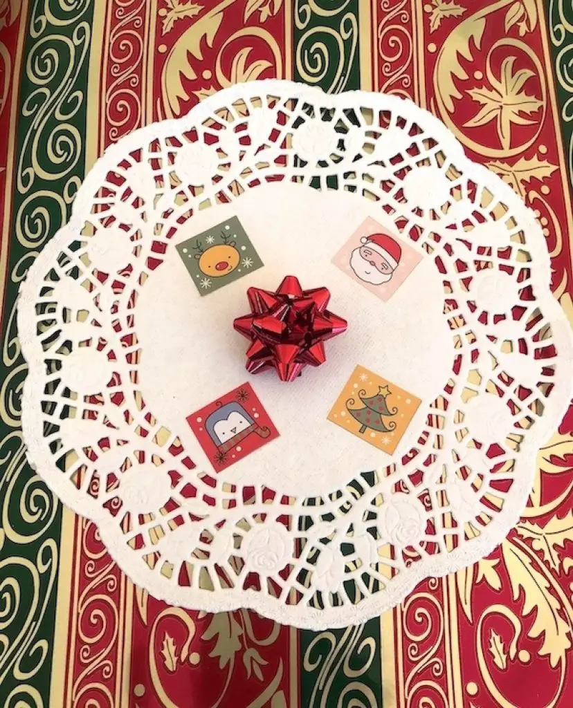 paper doily decorated with Christmas stickers and ribbons
