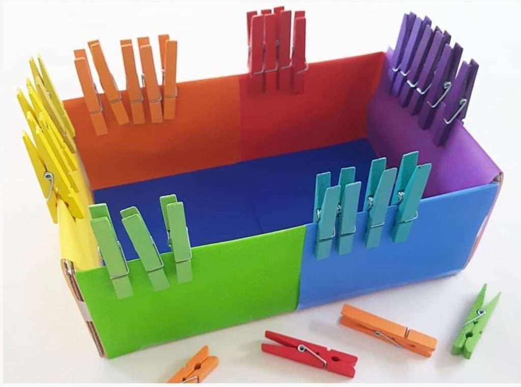 colored clothes pegs are attached to the box on their specified colors