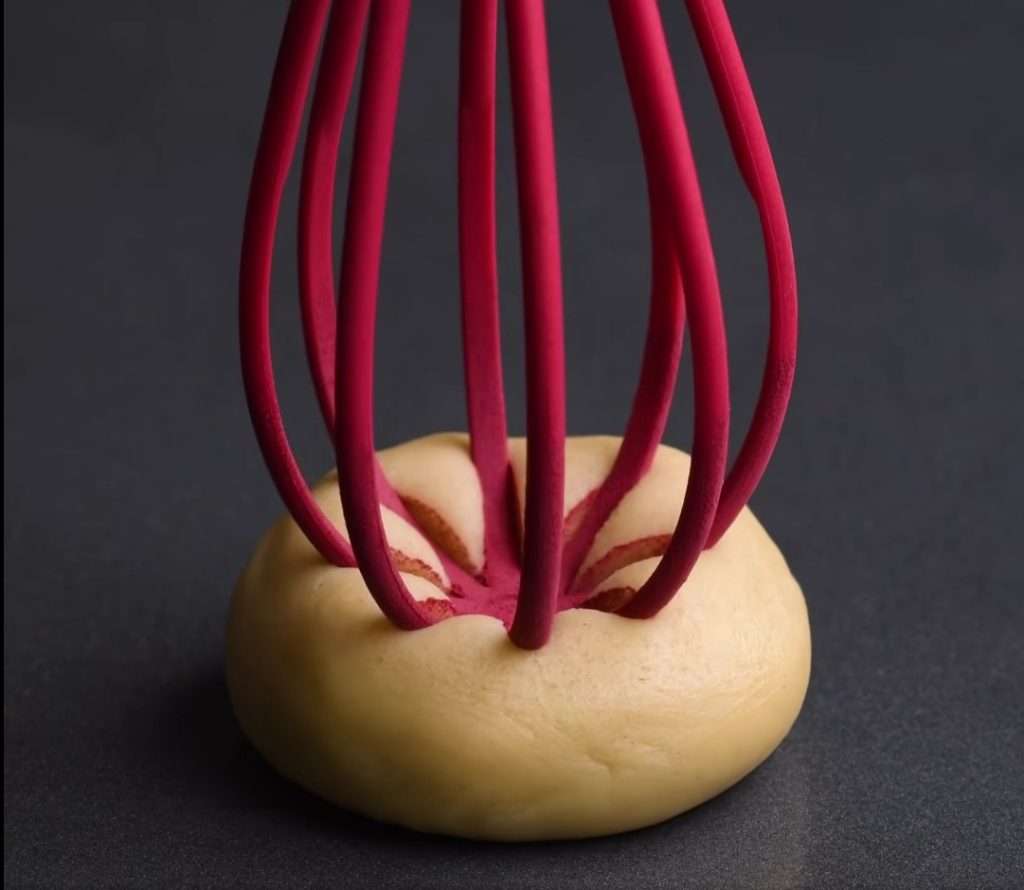 Pressing a powdered whisk into the dough