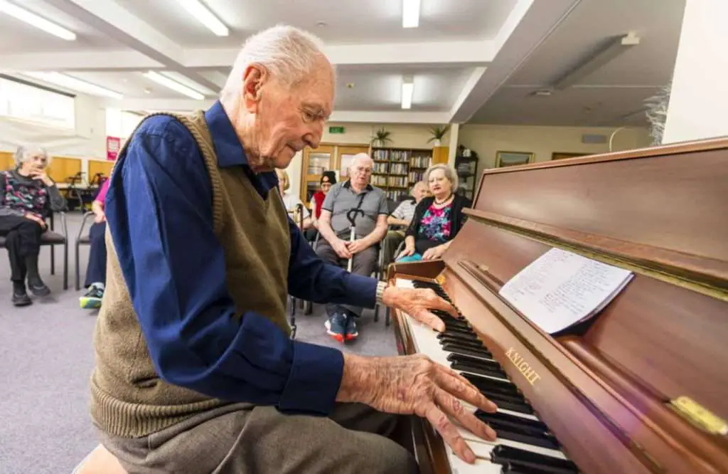 Elderly man playing piano in aged care