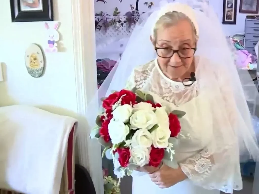 Elderly woman dressed in white for her entrance in the Renewing of wedding vows ceremony