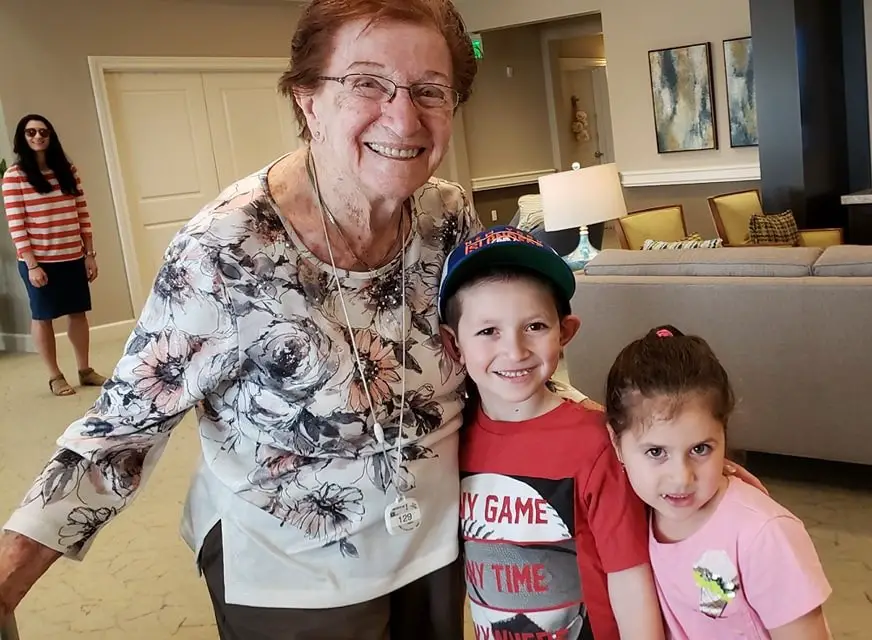 elderly woman taking a picture with children