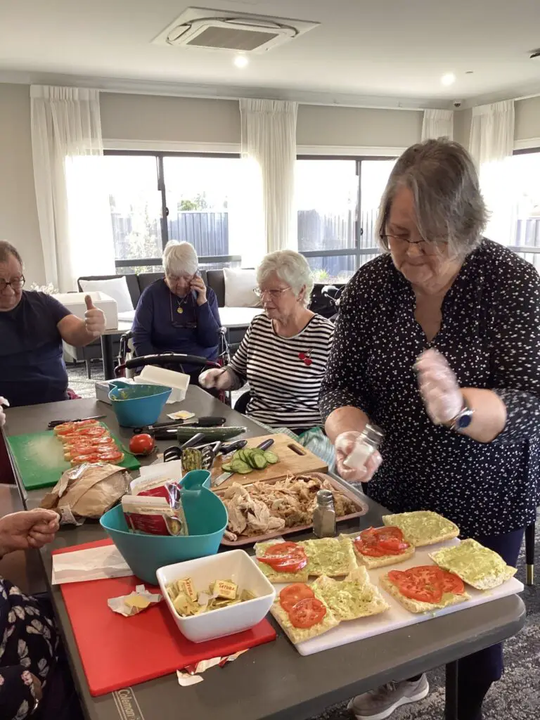 group of aged care seniors making healthy lunch together