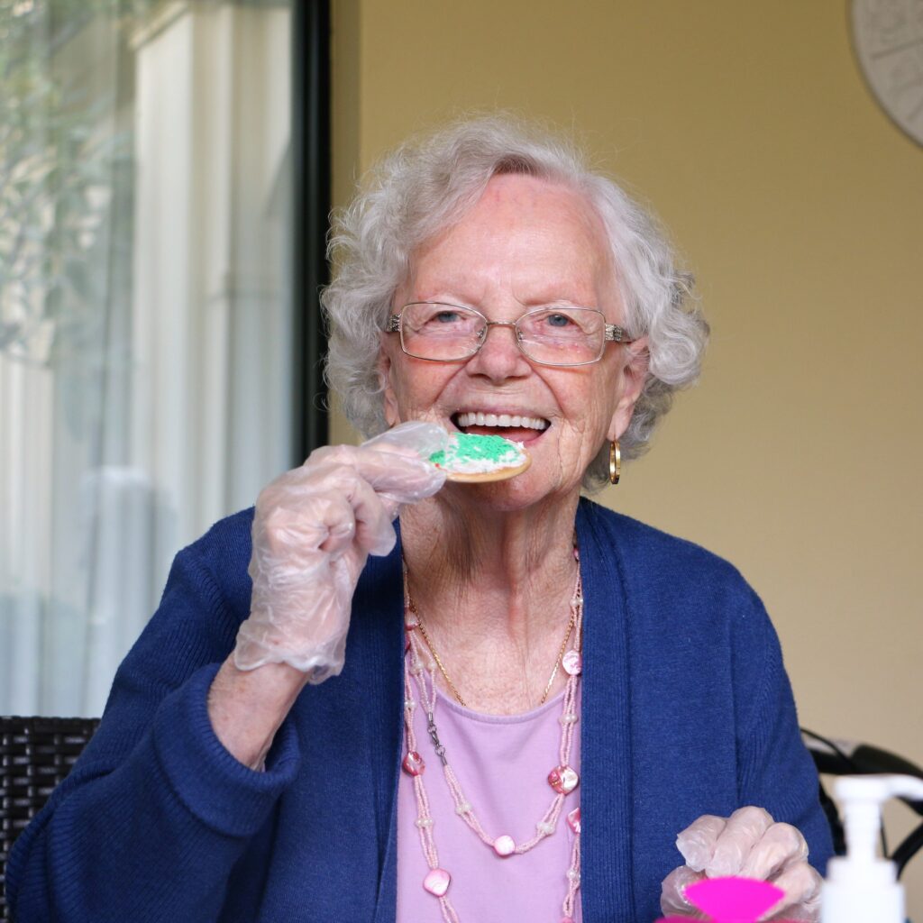 elderly lady eating cookie snack