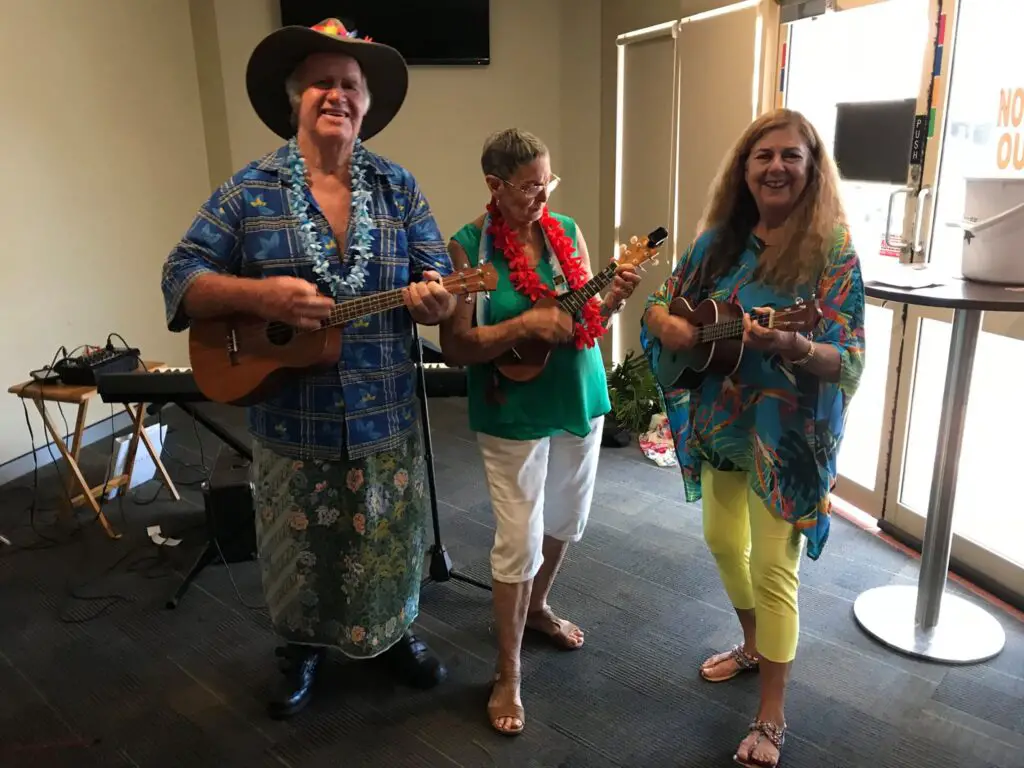 Seniors playing ukulele while dressed in Hawaiian Themed outfit