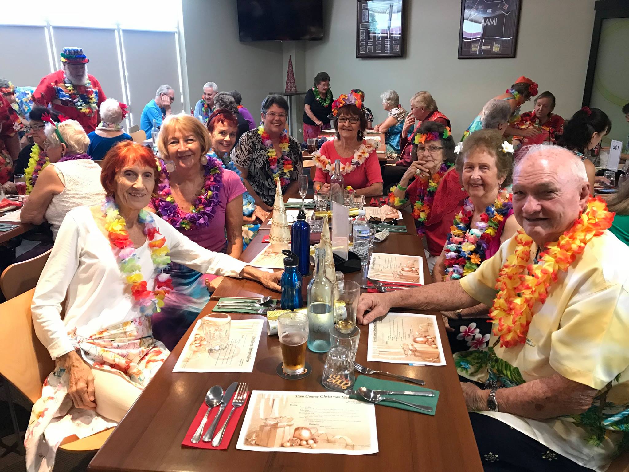 group of seniors dressed in Hawaiian theme while eating