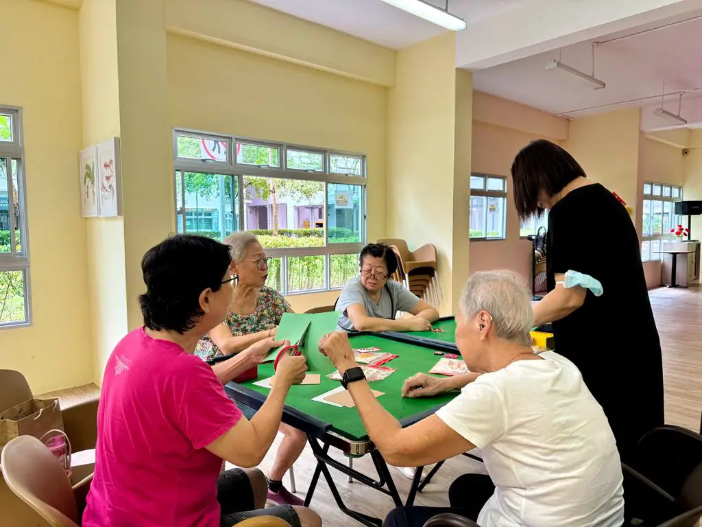 seniors in aged care cutting paper