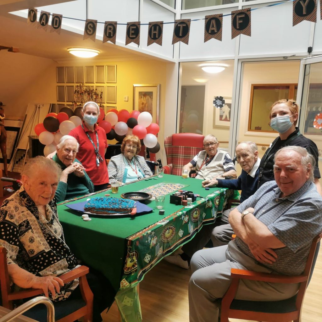 seniors in aged care sitting with staffs in a casino table