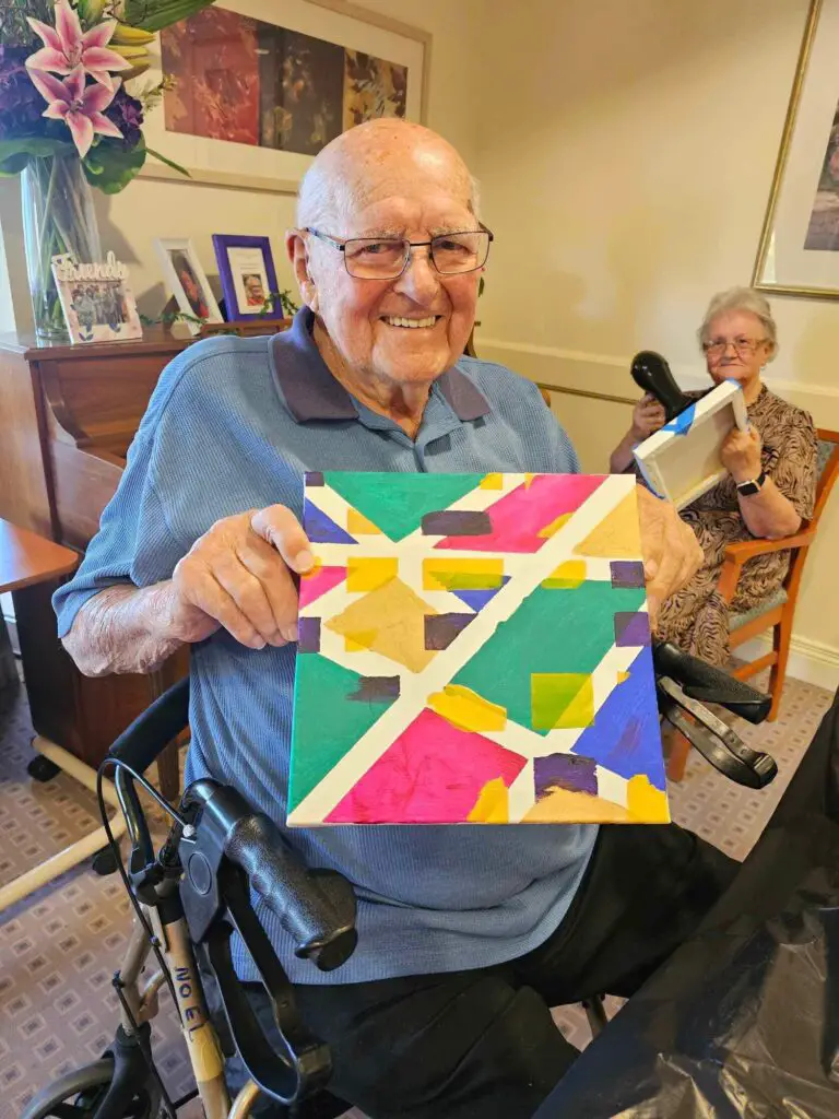 smiling elderly holding painting