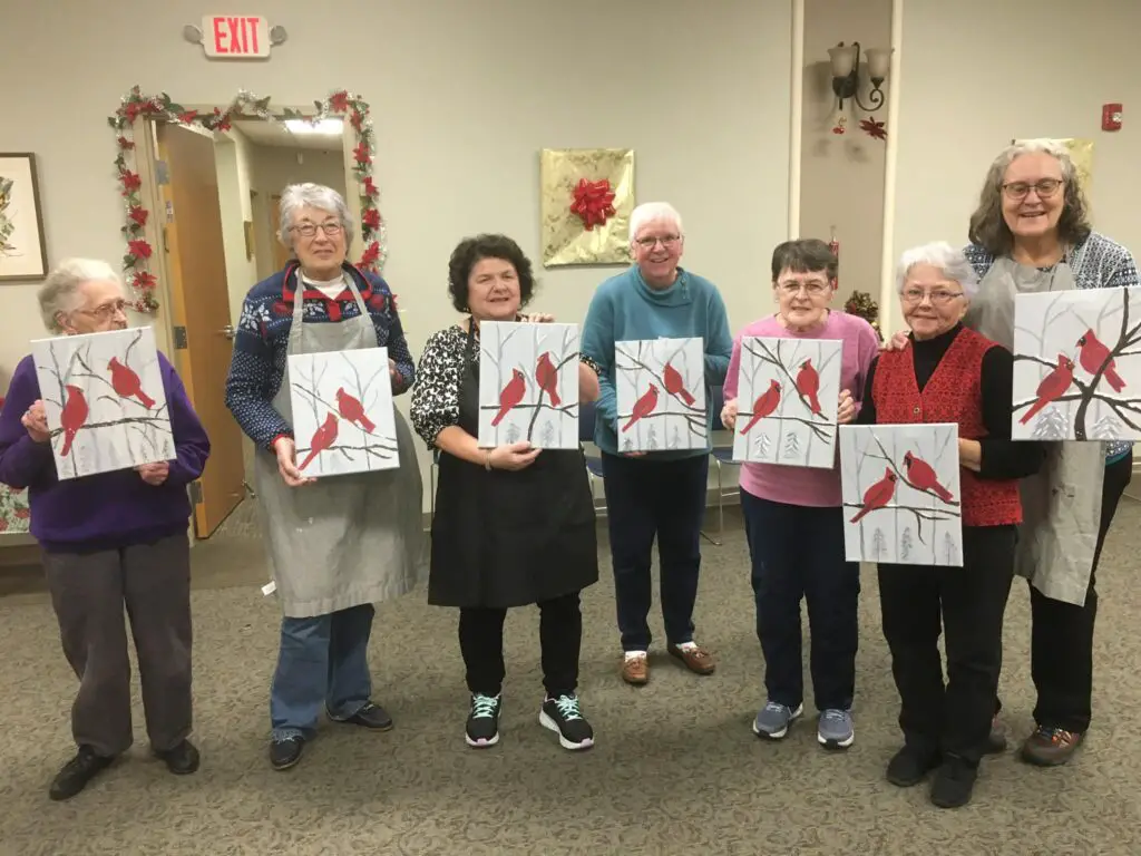 group of elderly ladies holding their bird paintings