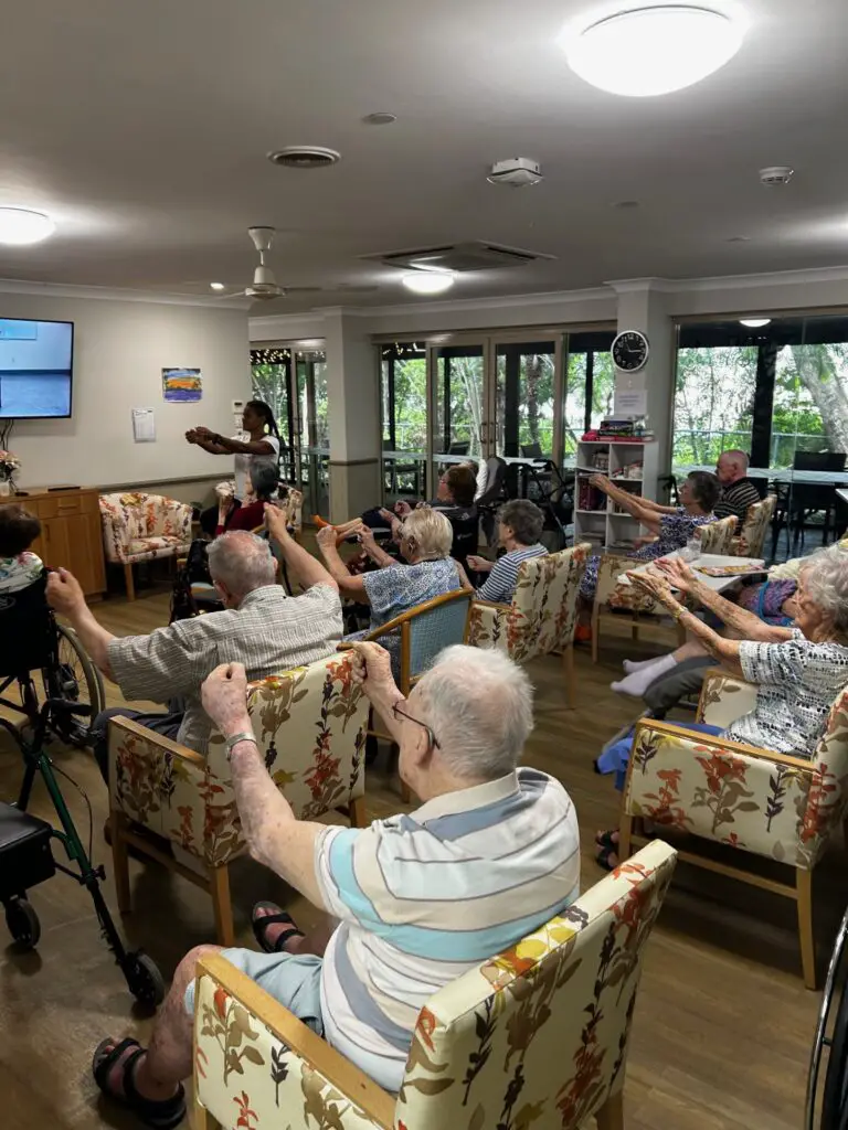 group of seniors doing seated dancing exercise