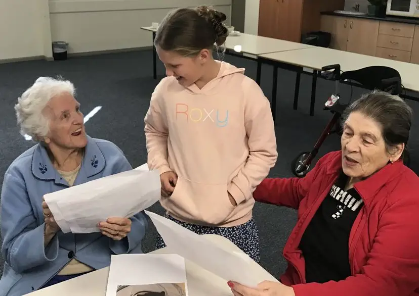 senior sharing their favorite childhood memory to a child visitor