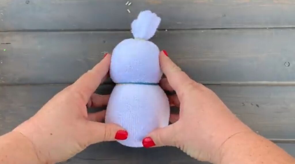 forming the sock snowman's head with a rubber band