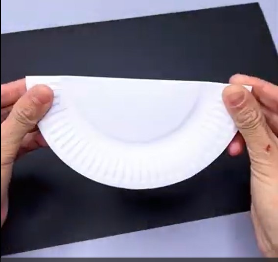 Folding the paper plate in half